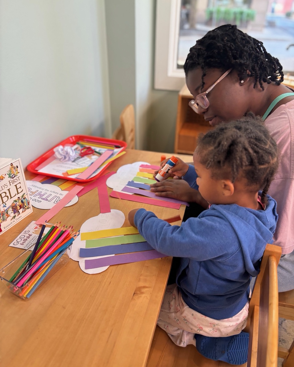 Children making a paper craft at a table