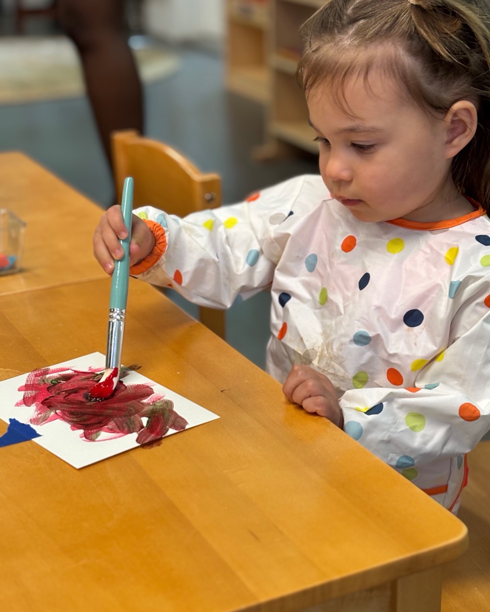 A child painting in a smock