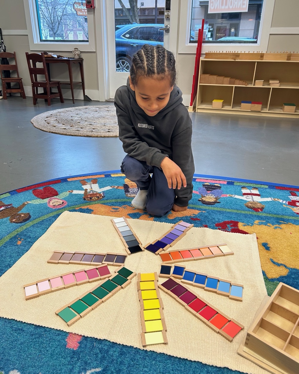 A child working with the color tablets on a rug