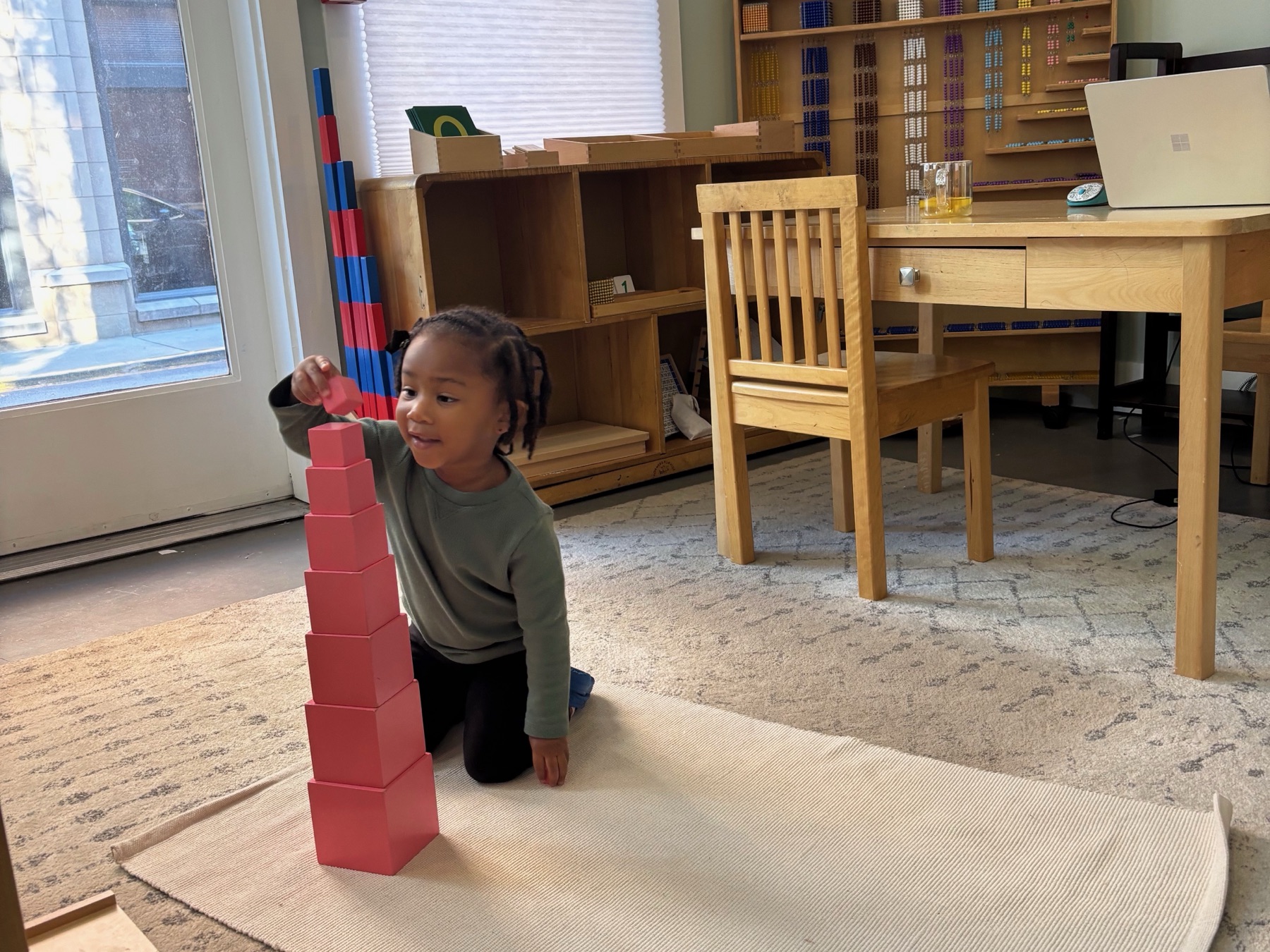 A child working independently on a rug